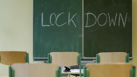 Klassenzimmer einer Schule mit einer Tafel und der Aufschrift Lockdown.
