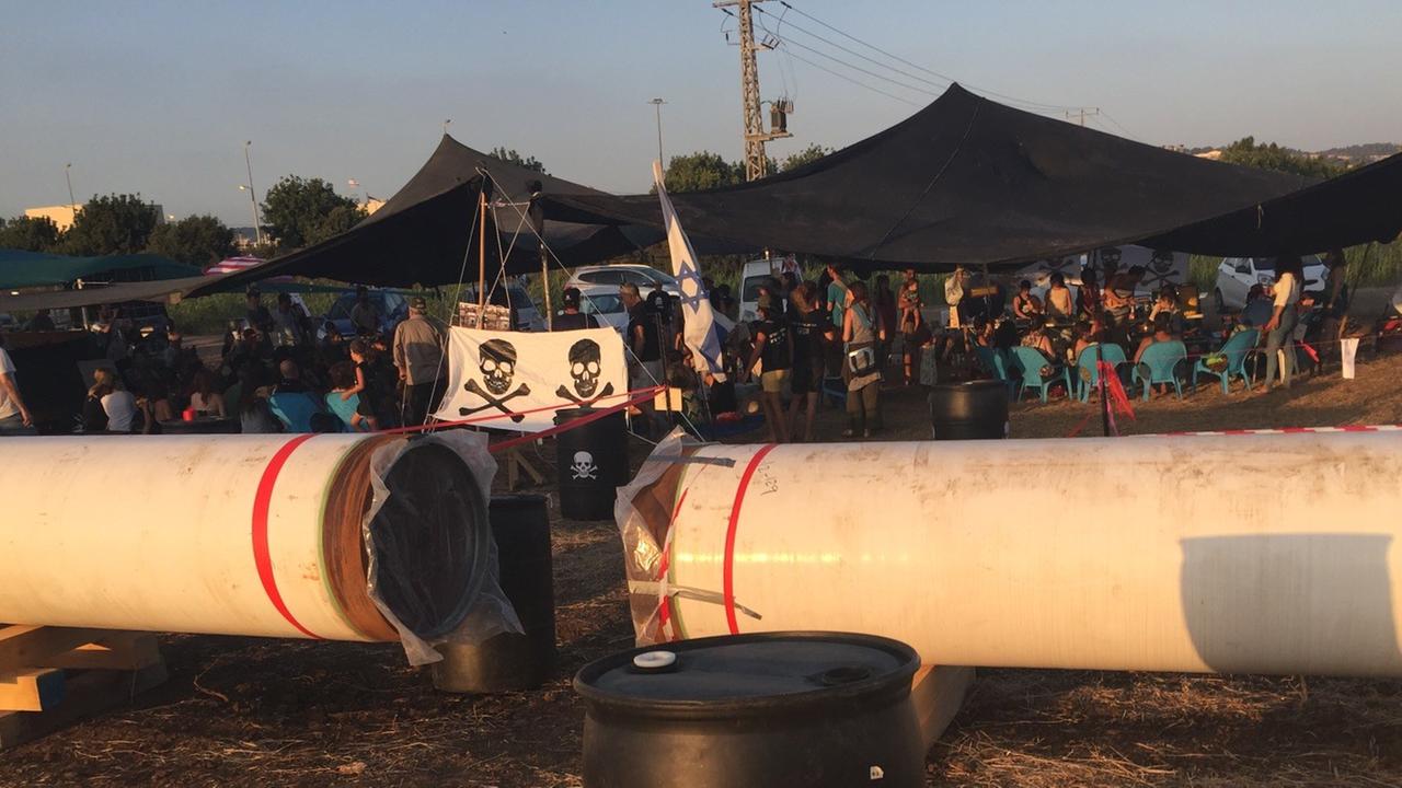 Erdgas-Gegner sitzen in der Nähe des Mittelmeerstrandes zwischen Tel Aviv und Haifa unter Planen. Ihr Erkennungszeichen, der Totenkopf ist auf Öltonnen, Plakaten und Auto-Fähnche zu sehen. Erdgas-Gegner sitzen in der Nähe des Mittelmeerstrandes zwischen Tel Aviv und Haifa unter Planen. Ihr Erkennungszeichen, der Totenkopf ist auf Öltonnen, Plakaten und Auto-Fähnche zu sehen.