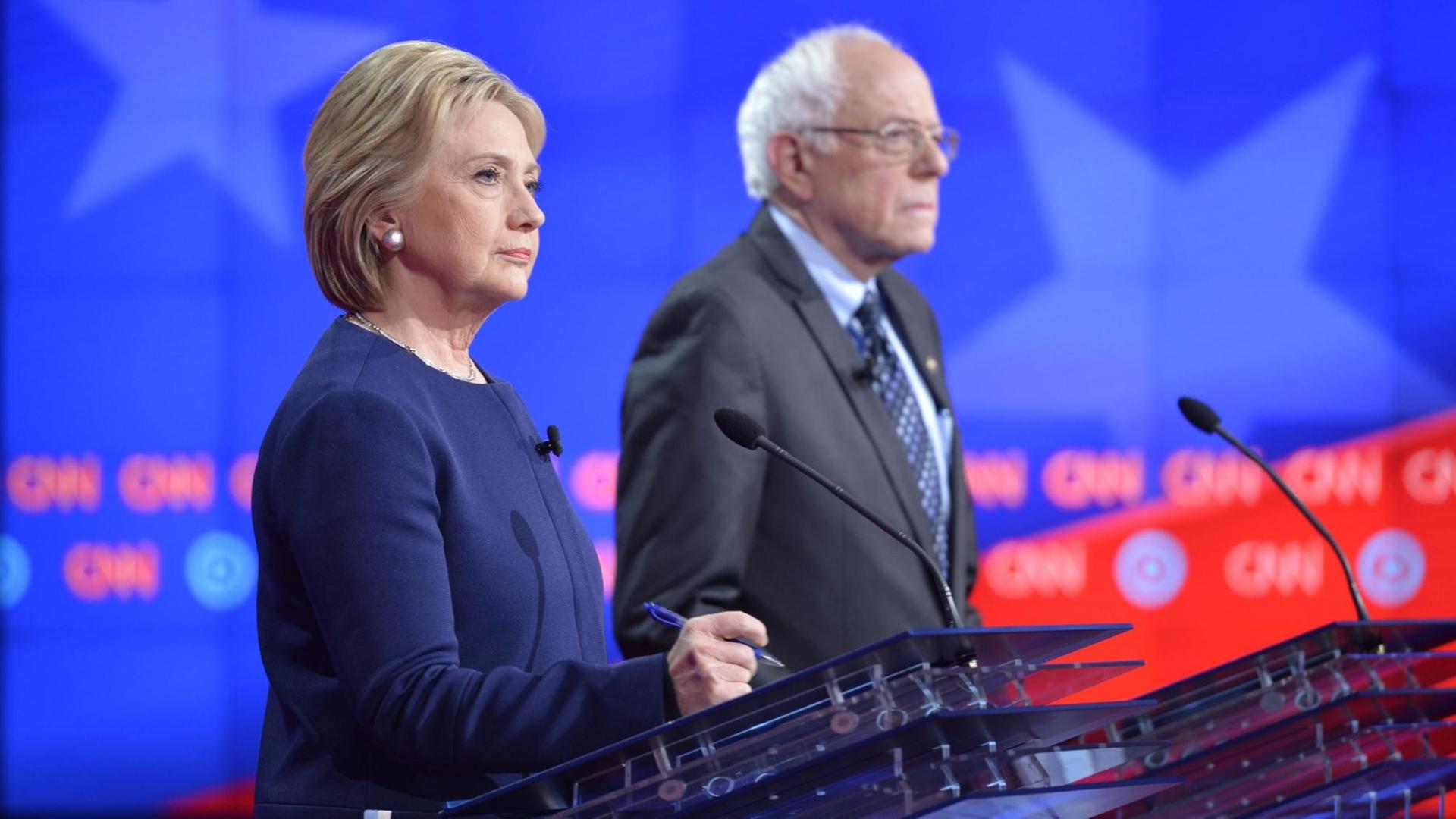 Ein Foto des US-Senders CNN zeigt Hillary Clinton neben Bernie Sanders während einer TV-Debatte der Demokraten im US-Bundesstaat Michigan. Ein Foto des US-Senders CNN zeigt Hillary Clinton neben Bernie Sanders während einer TV-Debatte der Demokraten im US-Bundesstaat Michigan.