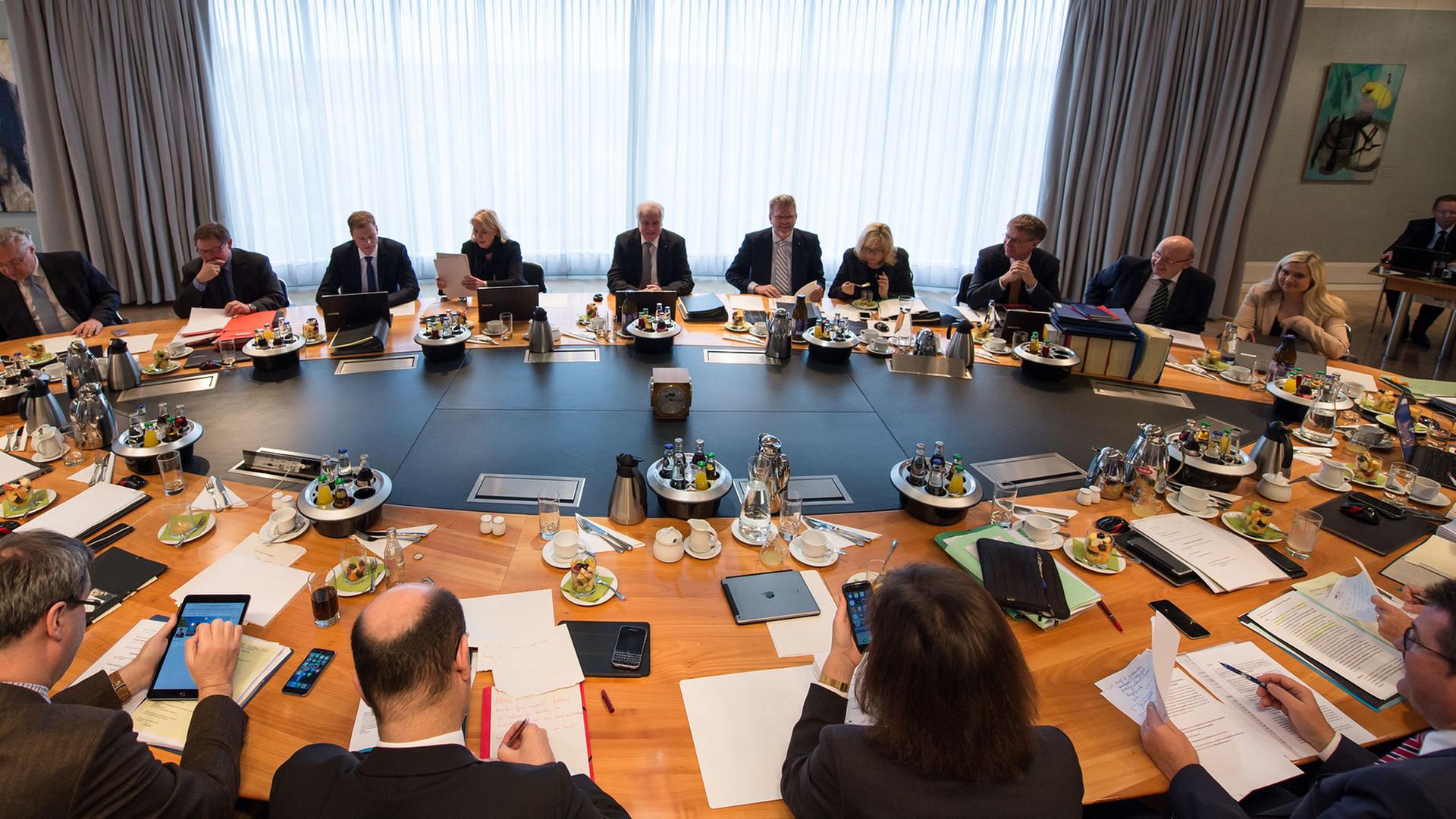 Die Kabinettsmitglieder der bayerischen Staatsregierung sitzen in München bei der Kabinettssitzung an einem ovalen Tisch.