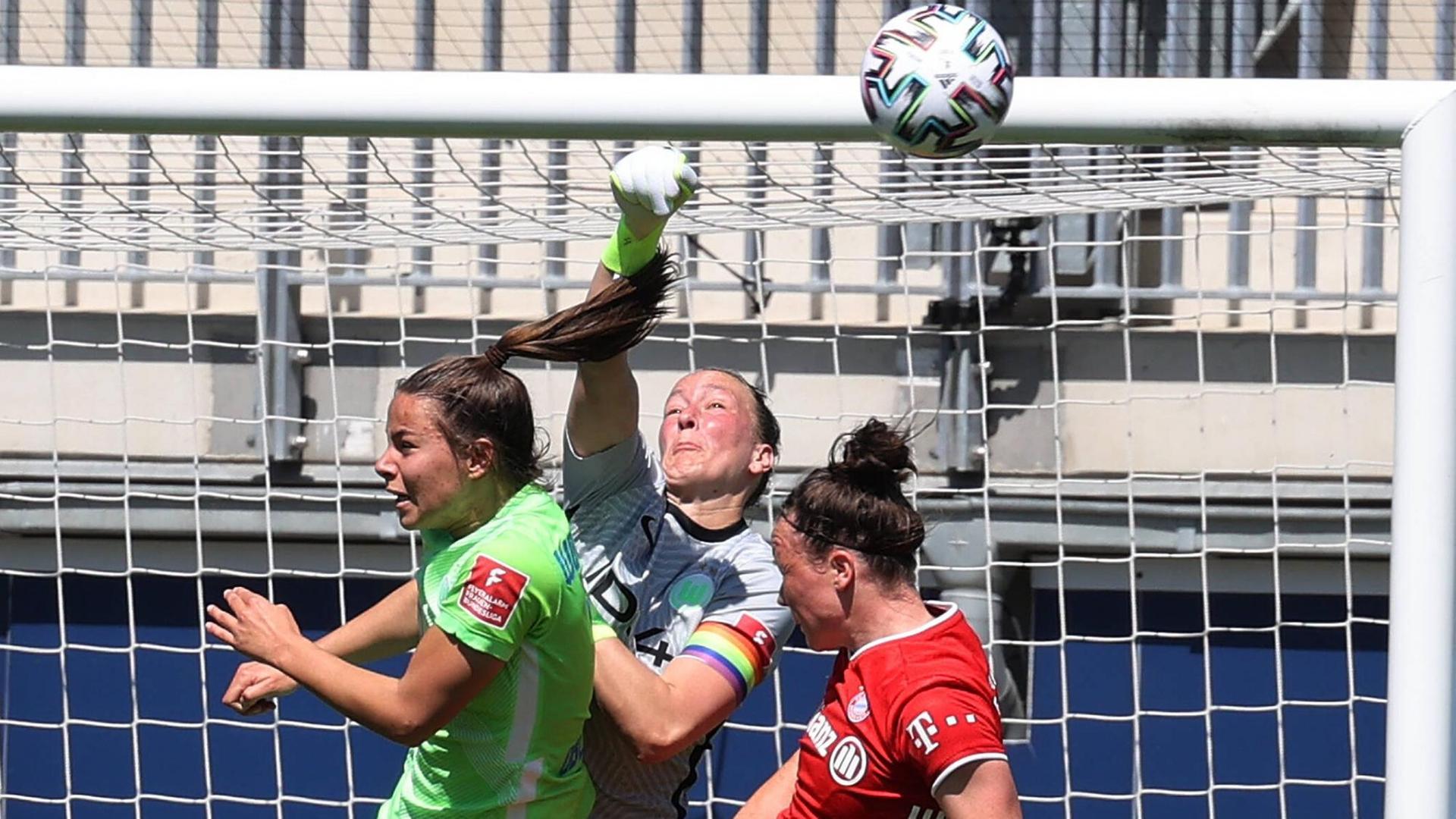 Das Foto zeigt drei Fußballerinnen vor einem Tor. Das Foto zeigt drei Fußballerinnen vor einem Tor.