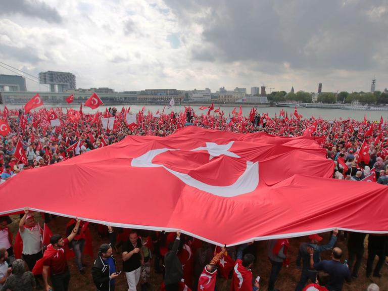 Anhänger des türkischen Staatspräsidenten Erdogan schwenken am 31.07.2016 in Köln (Nordrhein-Westfalen) türkische Fahnen. Mehrere Tausend Deutschtürken sind zu einer Pro-Erdogan-Demonstration in Köln zusammengekommen.
