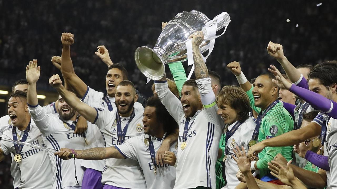Kapitän Sergio Ramos hält den Pokal in die Höhe, seine Mitspieler reißen die Arme hoch. Kapitän Sergio Ramos hält den Pokal in die Höhe, seine Mitspieler reißen die Arme hoch.