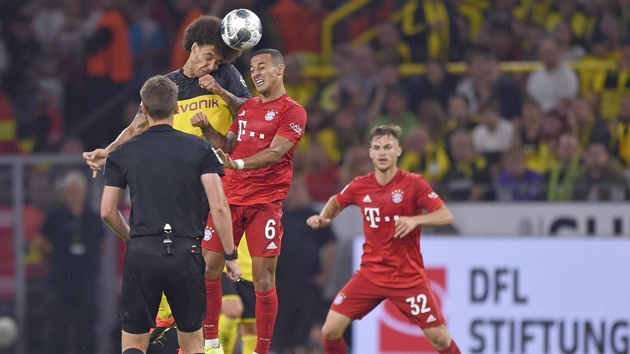 Spieler von Dortmund und München im Kampf um den Ball. Im Vordergrund steht der Schiedsrichter mit dem Rücken zur Kamera. Spieler von Dortmund und München im Kampf um den Ball. Im Vordergrund steht der Schiedsrichter mit dem Rücken zur Kamera.