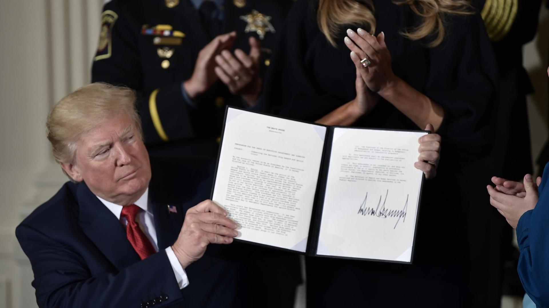 US-Präsident Donald Trump mit dem Dekret zur Ausrufung des nationalen Gesundheitsnotstandes. Jeden Tag sterben in den USA mehr als 100 Menschen durch Drogen. US-Präsident Donald Trump mit dem Dekret zur Ausrufung des nationalen Gesundheitsnotstandes. Jeden Tag sterben in den USA mehr als 100 Menschen durch Drogen.