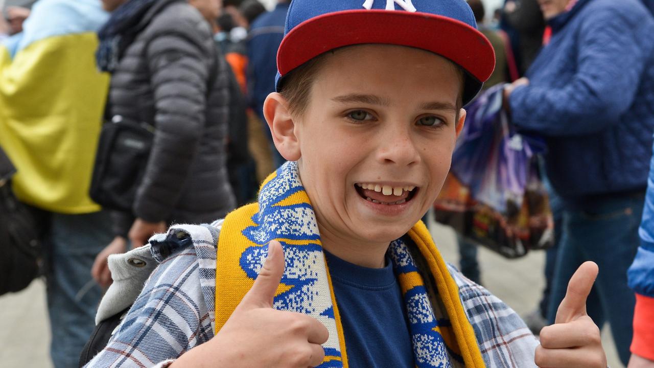 Daumen hoch! Die weltweit verstandene Geste zeigt dieser glückliche kleine Fußballfan aus der Ukraine. Daumen hoch! Die weltweit verstandene Geste zeigt dieser glückliche kleine Fußballfan aus der Ukraine.