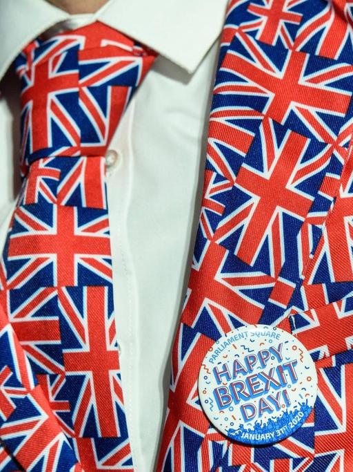 Ein englischer 'Pro-Brexit' Demonstrant mit einem 'Happy Brexit Day' Button am Anzug in Nationalfarben vor dem Parliament Square in London, 31. Januar, 2020.