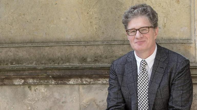 Roger Willemsen sitzt vor einer Wand des Schloss Albrechtsberg auf einem Vorsprung und lächelt freundlich in die Kamera. Roger Willemsen sitzt vor einer Wand des Schloss Albrechtsberg auf einem Vorsprung und lächelt freundlich in die Kamera.