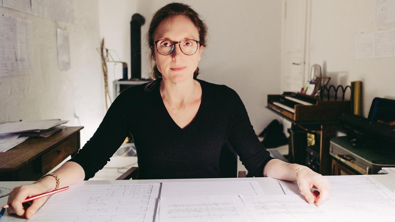 Rebecca Saunders sitzt in einem Arbeitszimmer an einem Schreibtisch Rebecca Saunders sitzt in einem Arbeitszimmer an einem Schreibtisch