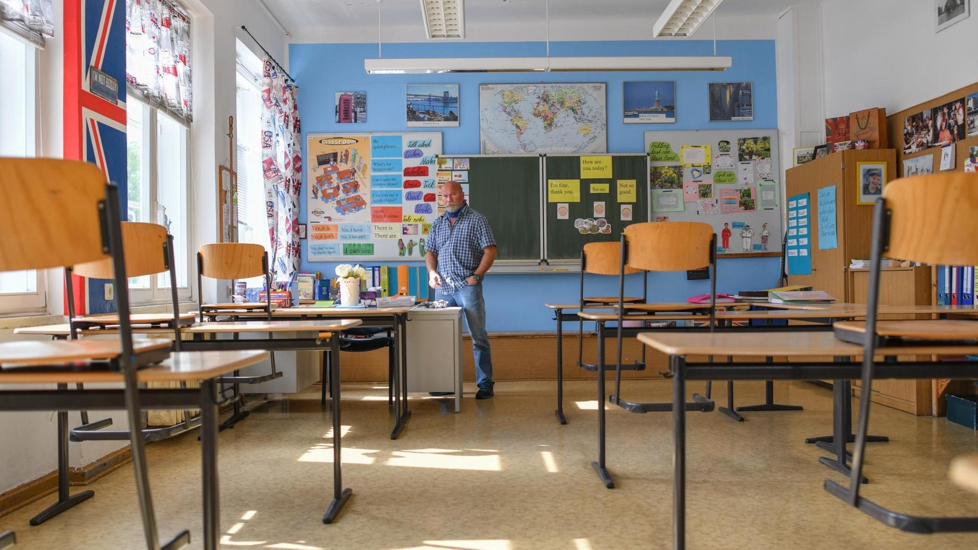 Ein leeres Klassenzimmeer mit blau gestrichener Wand und viel Dekoration.