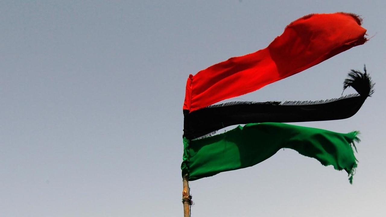 Die zerfetzte libysche Flagge, befestigt an einem LKW. Die zerfetzte libysche Flagge, befestigt an einem LKW.