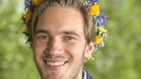 Youtuber Felix "PewDiePie" Kjellber trägt blaue und gelbe Blumen im blonden Haar.