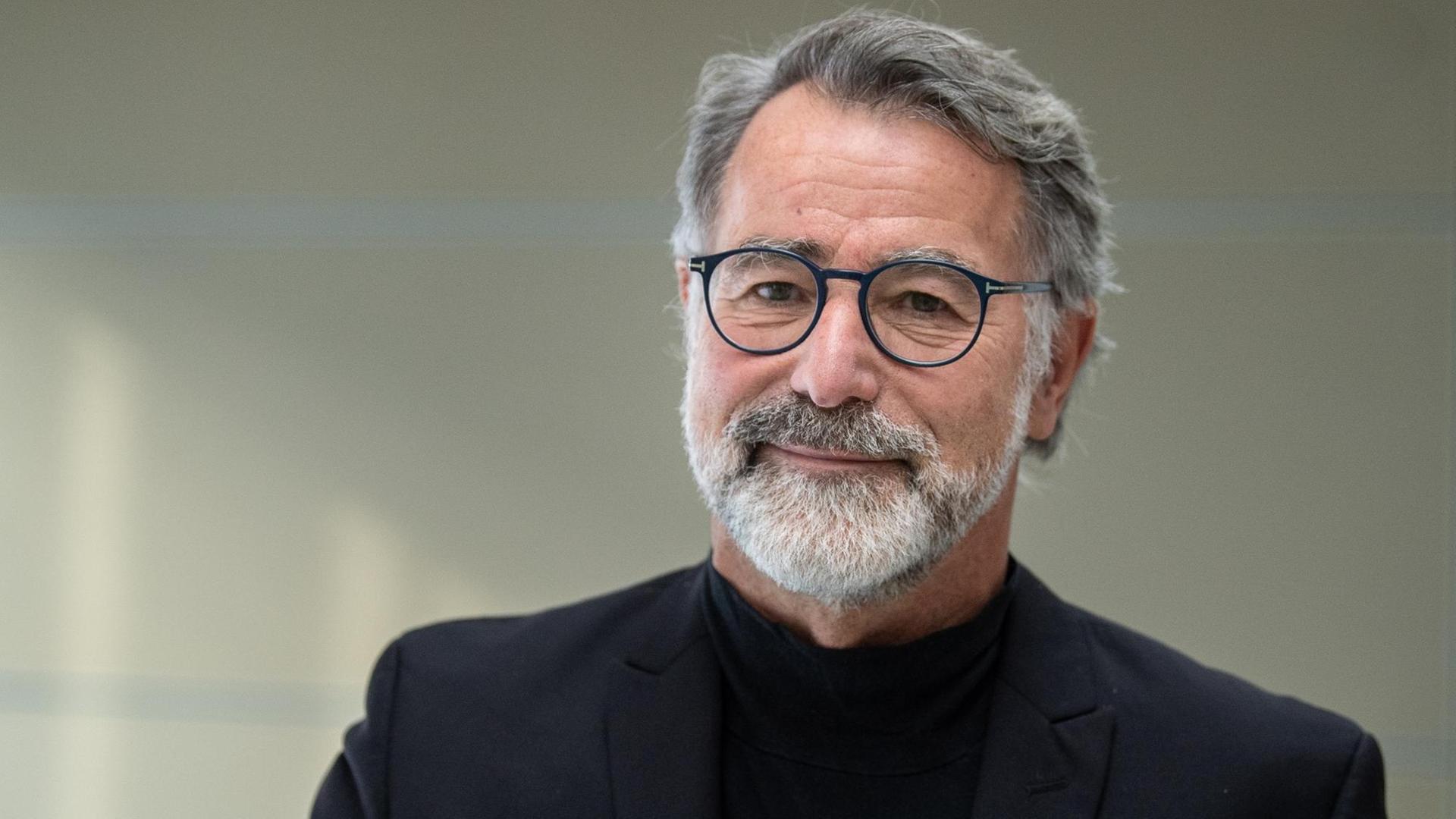 Wolfgang Merkel trägt einen Bart, er ist vor einem neutralen Hintergrund fotografiert. Wolfgang Merkel trägt einen Bart, er ist vor einem neutralen Hintergrund fotografiert.