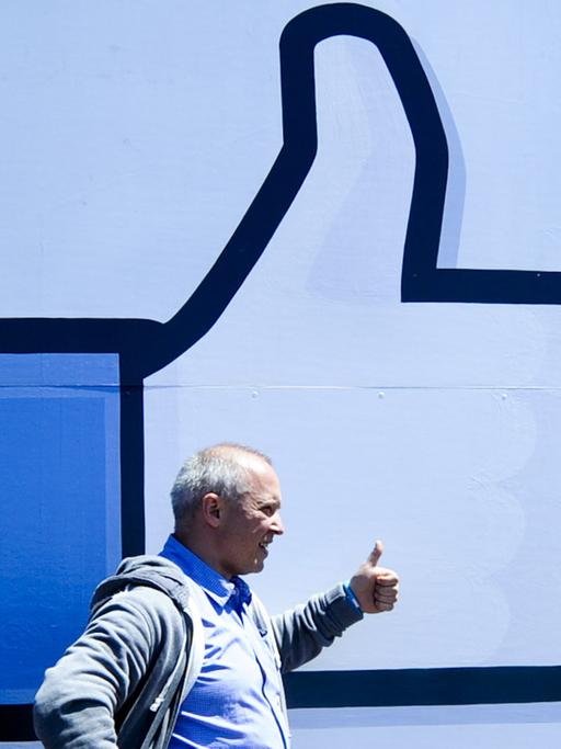 Mann vor der Gefällt-mir-Geste von Facebook
