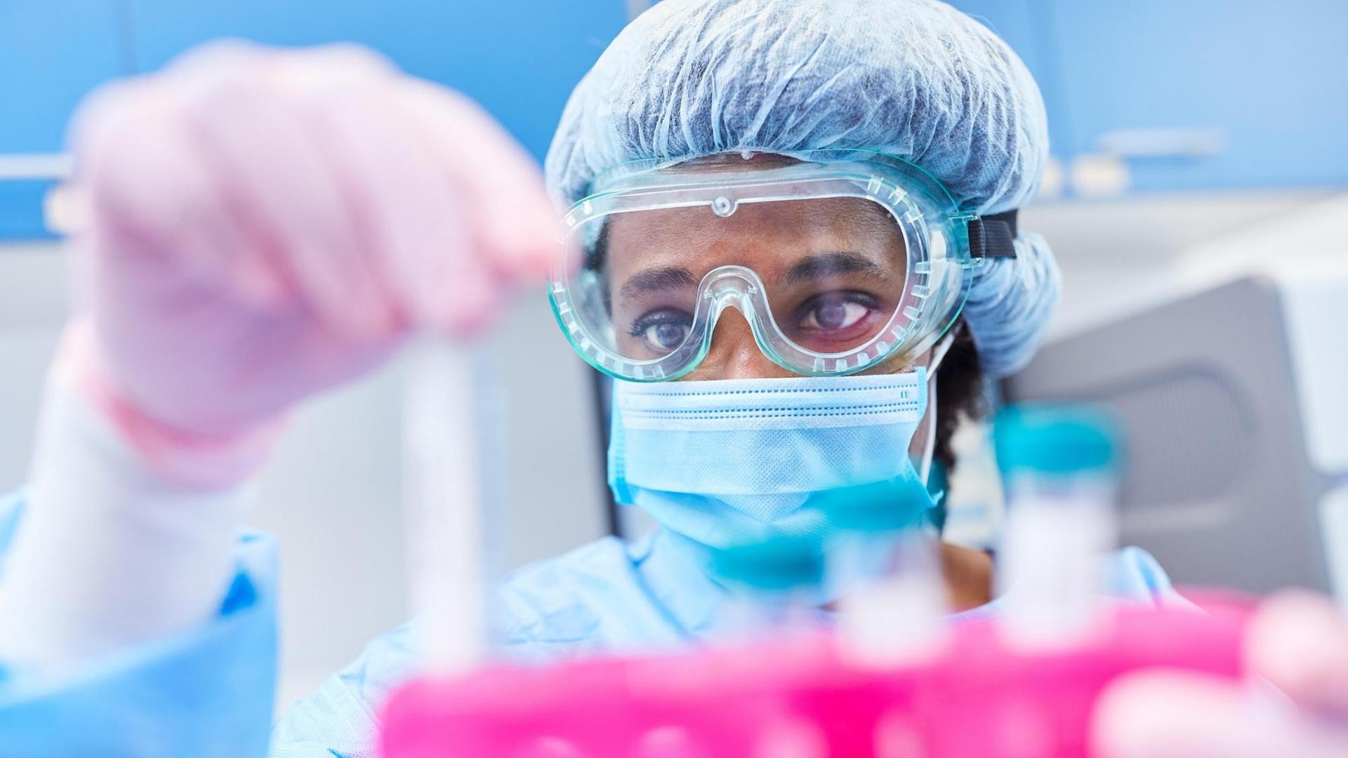 Ein Mediziner untersucht Covid-19-Proben im Labor auf Mutationen und Gensequenzen Ein Mediziner untersucht Covid-19-Proben im Labor auf Mutationen und Gensequenzen