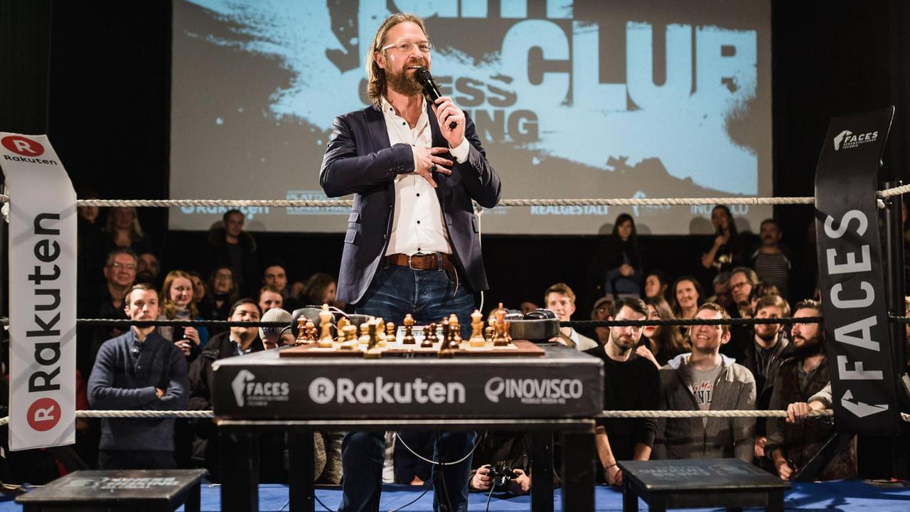 Iepe Rubingh steht im Boxring vor einem Tisch mit einem Schachbrett. Iepe Rubingh steht im Boxring vor einem Tisch mit einem Schachbrett.