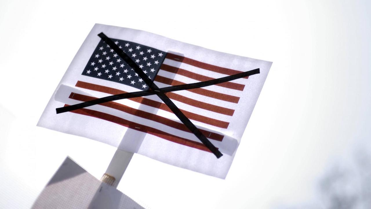 Demonstranten mit einem Transparent gegen die USA auf der Demonstration der Friedensbewegung zum Ostermarsch 2016 in Berlin. Demonstranten mit einem Transparent gegen die USA auf der Demonstration der Friedensbewegung zum Ostermarsch 2016 in Berlin.