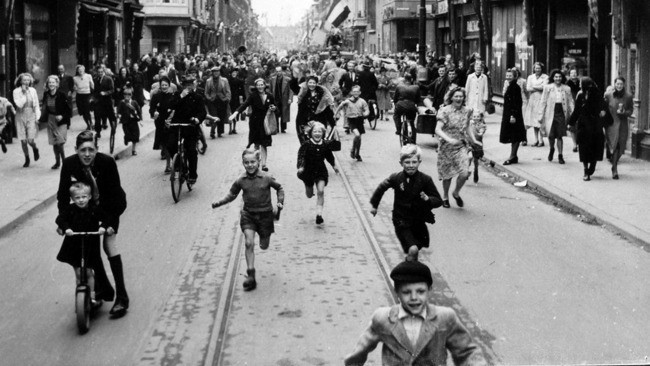 Jubelnde Menschen auf der Straße - aufgenommen am Tag der Befreiung der Niederlande von den deutschen Besatzern am 5. Mai 1945 Jubelnde Menschen auf der Straße - aufgenommen am Tag der Befreiung der Niederlande von den deutschen Besatzern am 5. Mai 1945