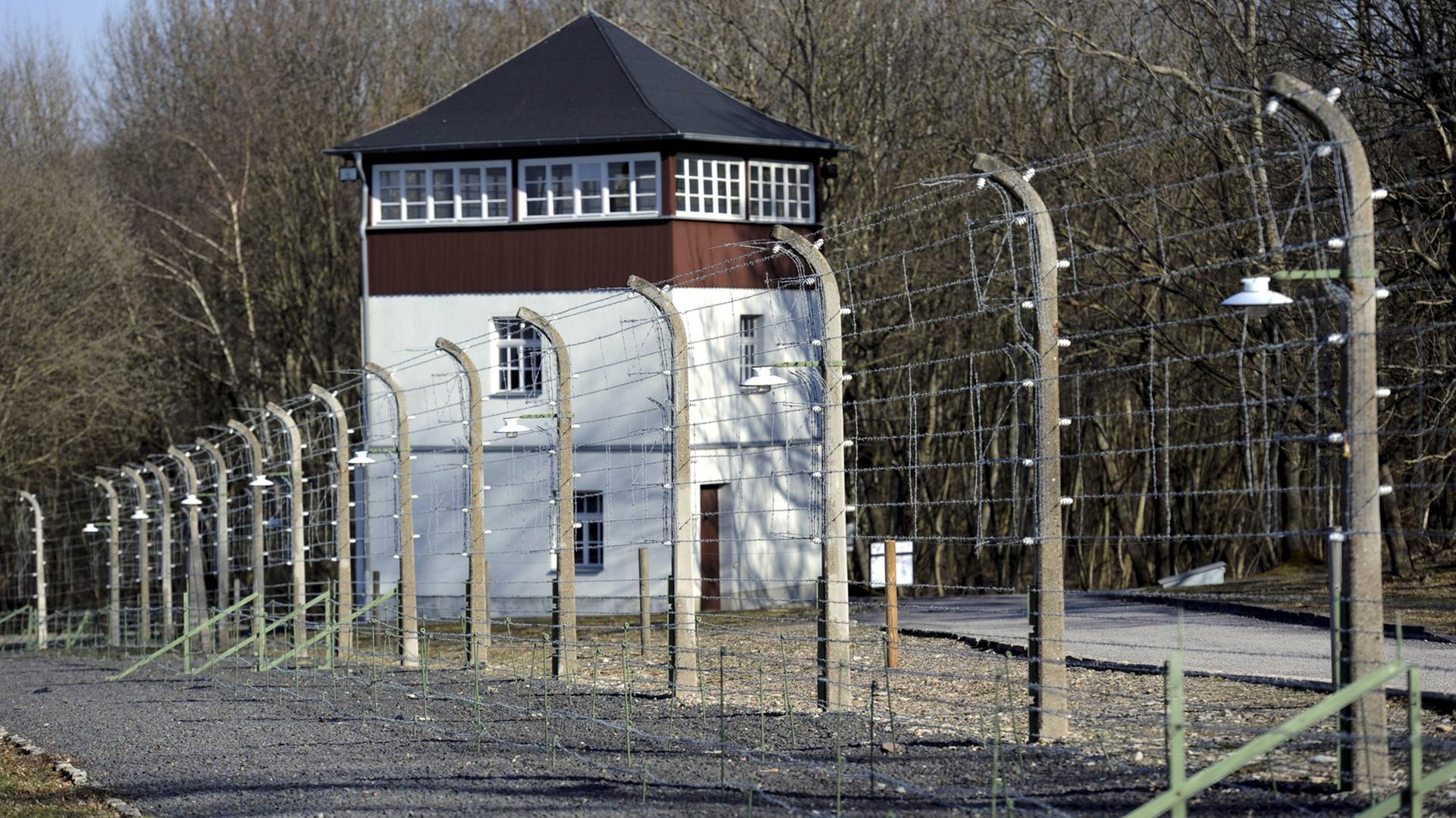 Ein zweistöckiger Wachturm hinter einem Stacheldrahtzaun. Ein zweistöckiger Wachturm hinter einem Stacheldrahtzaun.
