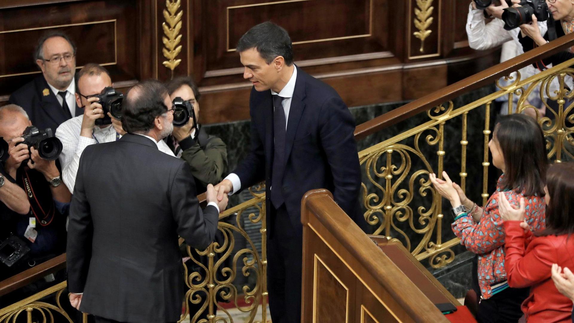 Der vom Parlament abgewählte Ministerpräsident Rajoy schüttelt seinem Nachfolger Pedro Sánchez im Parlament die Hand.