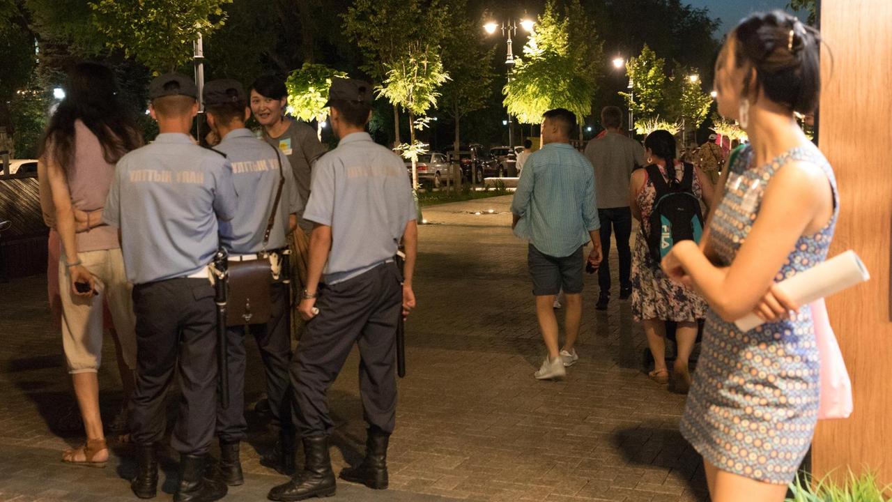 Junge Leute, Polizisten stehen in einer Fußgängerzone in Nur-Sultan, Kasachstan. Junge Leute, Polizisten stehen in einer Fußgängerzone in Nur-Sultan, Kasachstan.
