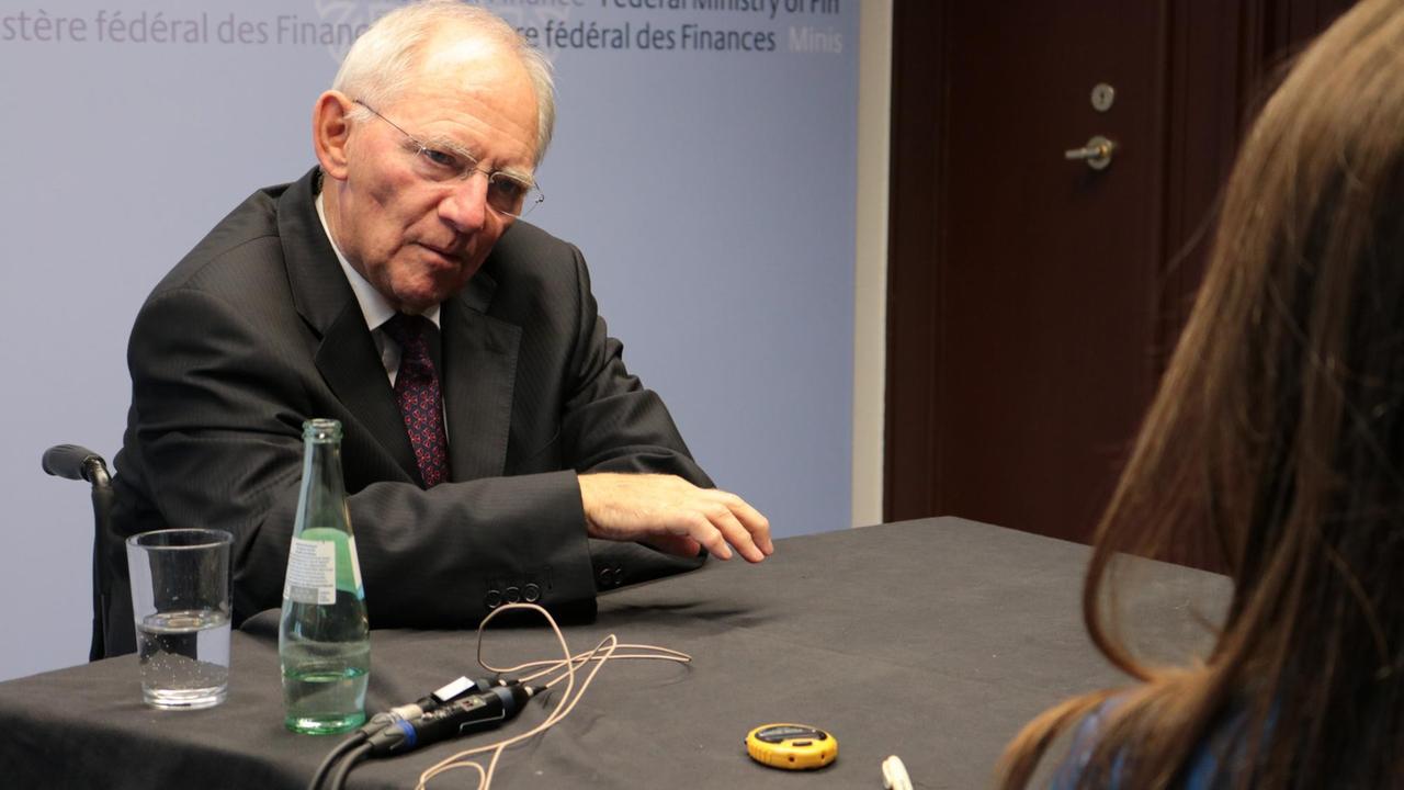 Bundesfinanzminister Wolfgang Schäuble sitzt an einem Tisch vor einem Mikrofon. Ihm gegenüber Deutschlandfunk-Redakteurin Christiane Florin