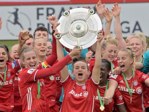 Die Spielerinnen vom FC Bayern München jubeln nach Spielende über den Sieg und über die Deutsche Meisterschaft mit der Meisterschale.