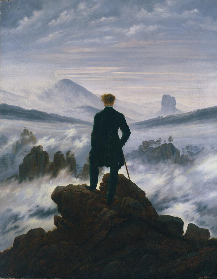 Ein Mann steht auf einem Berg und blickt in ein Nebelmeer aus dem Bergspitzen herausragen. Ein Mann steht auf einem Berg und blickt in ein Nebelmeer aus dem Bergspitzen herausragen.