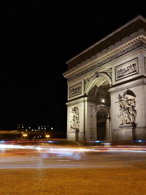 Das Foto zeigt den Triumphbogen in Paris in der Nacht.