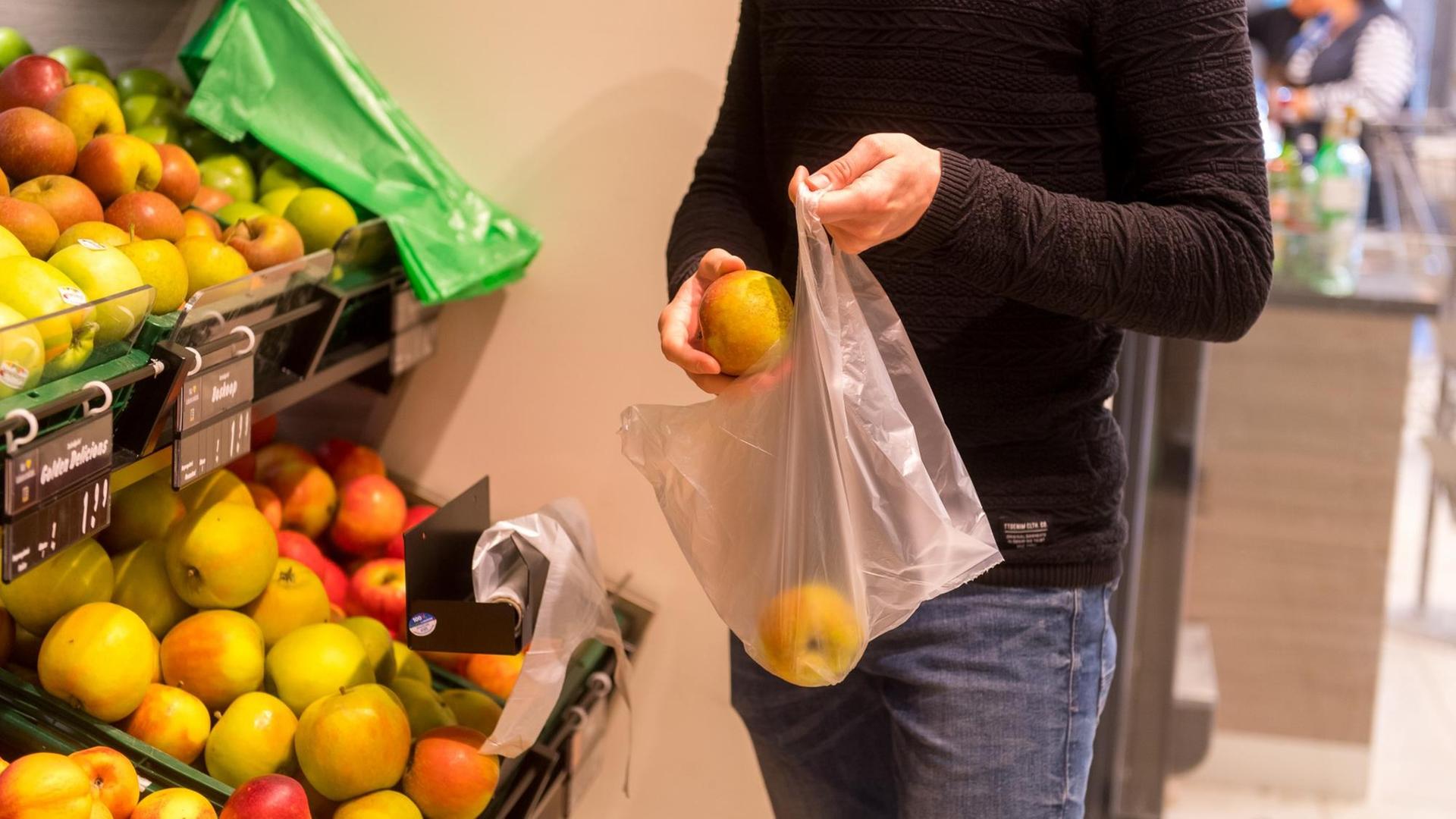 Ein Mann packt in einem Supermarkt in Flensburg Obst in einen Plastikbeutel Ein Mann packt in einem Supermarkt in Flensburg Obst in einen Plastikbeutel