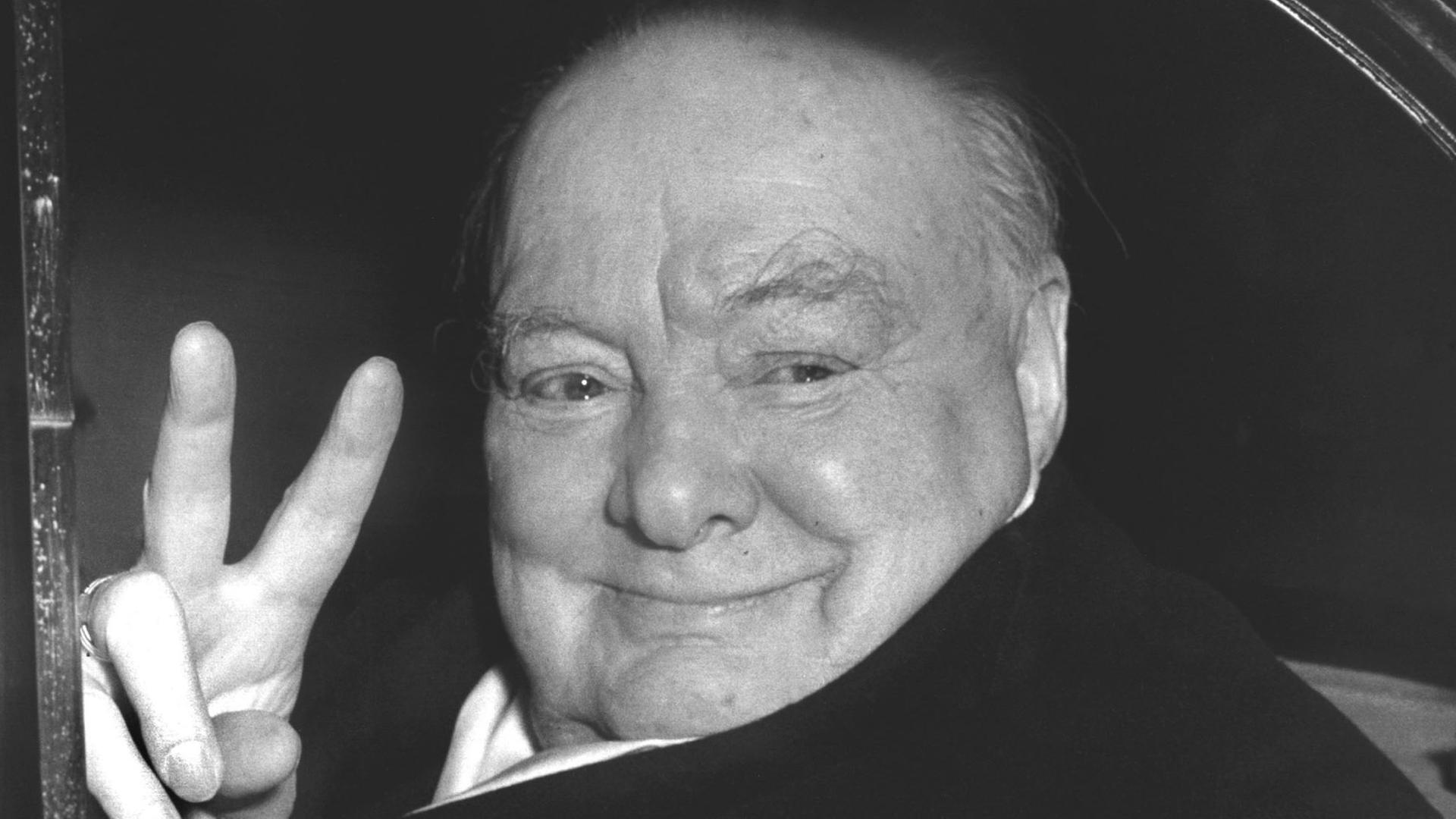 Der britische Staatsmann Sir Winston Churchill (1874-1965) grüßt aus einem Fahrzeug heraus mit der für ihn typischen Geste, dem Victory-Zeichen. Der britische Staatsmann Sir Winston Churchill (1874-1965) grüßt aus einem Fahrzeug heraus mit der für ihn typischen Geste, dem Victory-Zeichen.