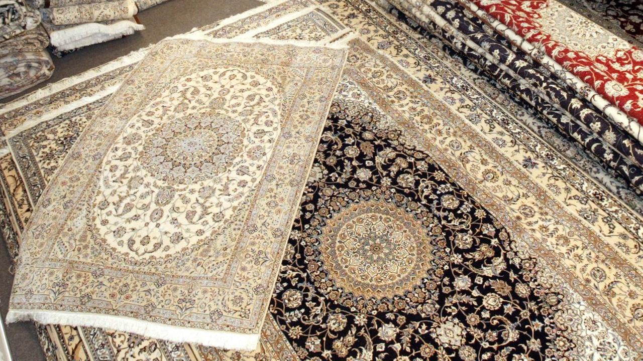 Perser-Teppiche werden von Mitarbeitern eines Ausstellers aus dem Iran in Hannover vor Beginn der Teppich-Messe Domotex sortiert Perser-Teppiche werden von Mitarbeitern eines Ausstellers aus dem Iran in Hannover vor Beginn der Teppich-Messe Domotex sortiert