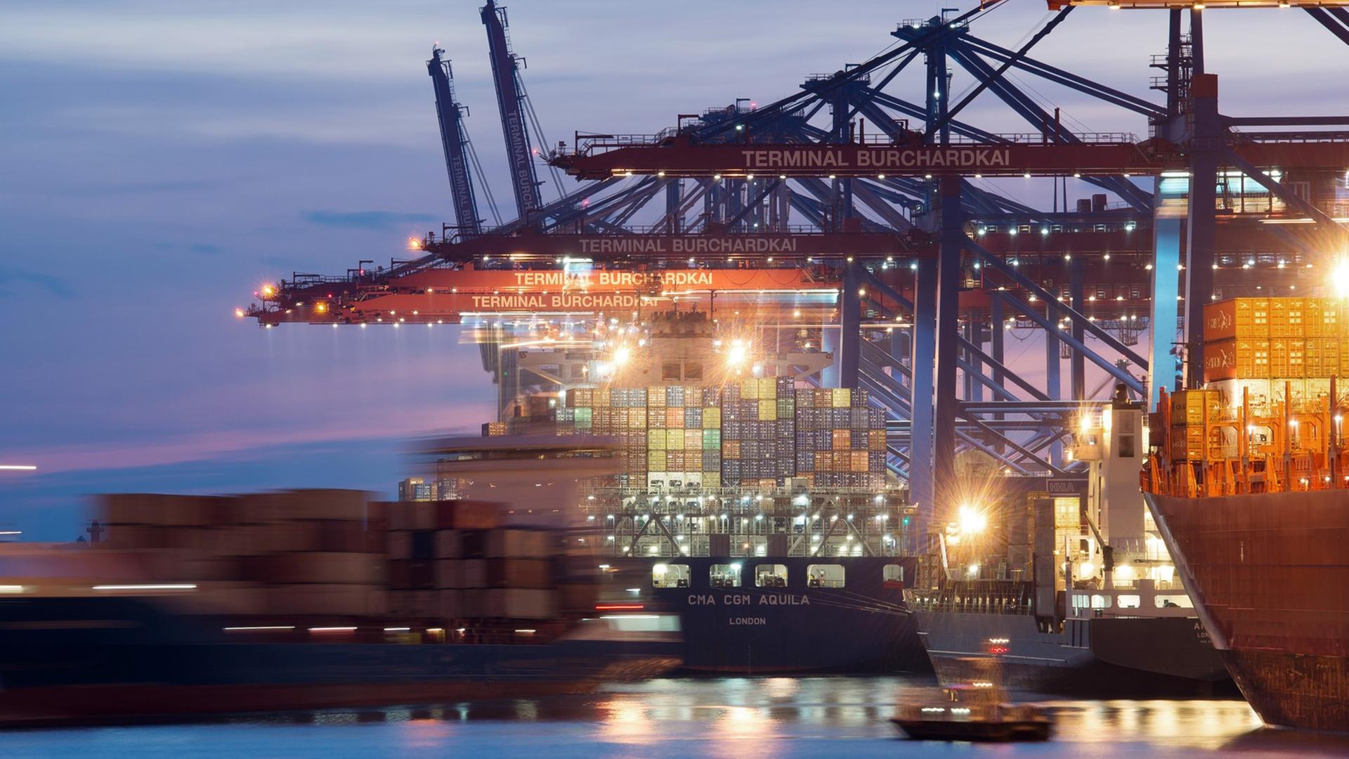 Containerschiffe liegen kurz nach Sonnenuntergang im Hafen in Hamburg am Terminal Burchardkai. Containerschiffe liegen kurz nach Sonnenuntergang im Hafen in Hamburg am Terminal Burchardkai.