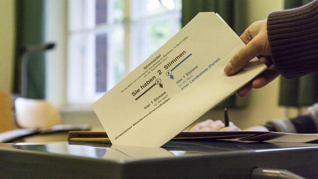 Eine Wählerin wirft bei der Bundestagswahl 2017 einen Stimmzettel in eine Urne Eine Wählerin wirft bei der Bundestagswahl 2017 einen Stimmzettel in eine Urne