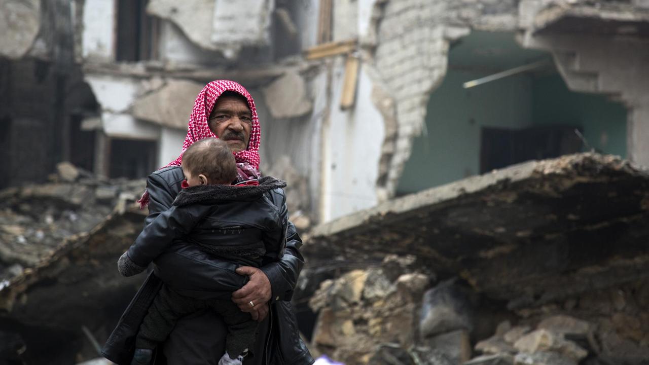 Zivilisten in Aleppo: Ein Vater hält ein Kleinkind im Arm. Zivilisten in Aleppo: Ein Vater hält ein Kleinkind im Arm.
