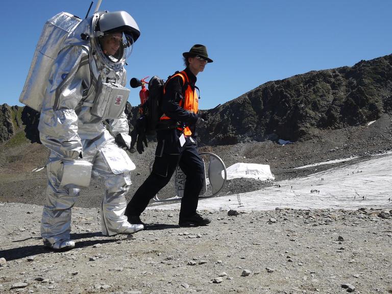 Die Analog-Astronautin (Forscher im Raumanzug), Carmen Köhler aus Berlin (l), geht auf dem Kaunertaler Gletscher (Österreich) in ihrem 45 Kilogramm schweren Raumanzug.