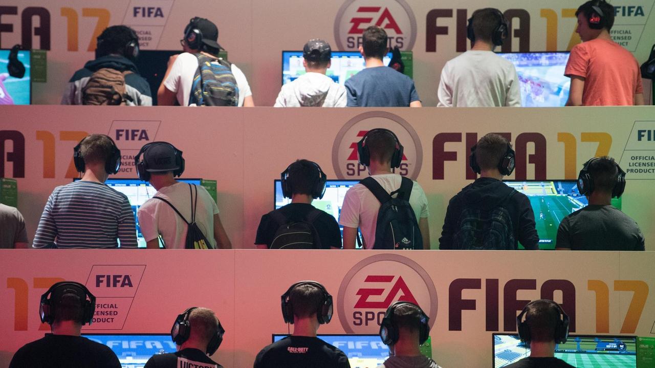 Besucher spielen auf der Spielemesse Gamescom in Köln das Spiel "FIFA 17". 