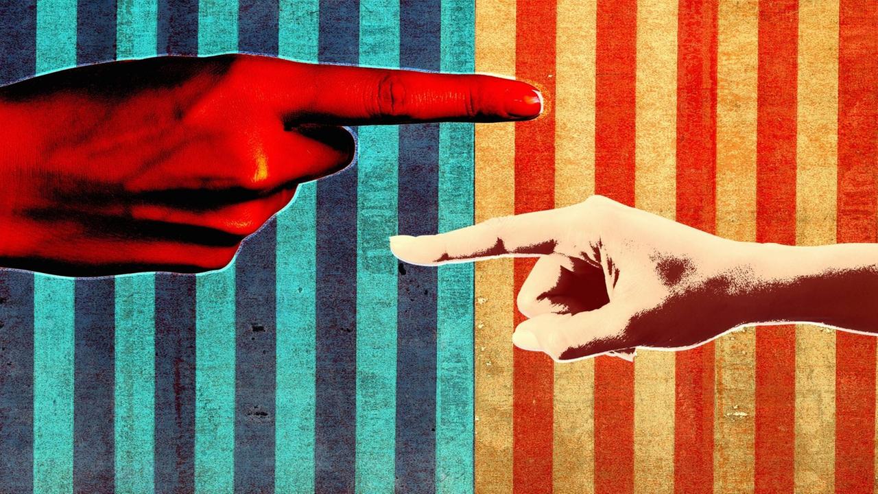 Vor dem Hintergrund der US-amerikanischen Nationalflagge zeigen zwei Finger vorwurfslos auf die jeweils gegenüber liegende Seite. Vor dem Hintergrund der US-amerikanischen Nationalflagge zeigen zwei Finger vorwurfslos auf die jeweils gegenüber liegende Seite.