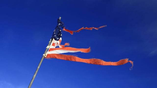 Eine zerfledderte Flagge der USA weht im Wind