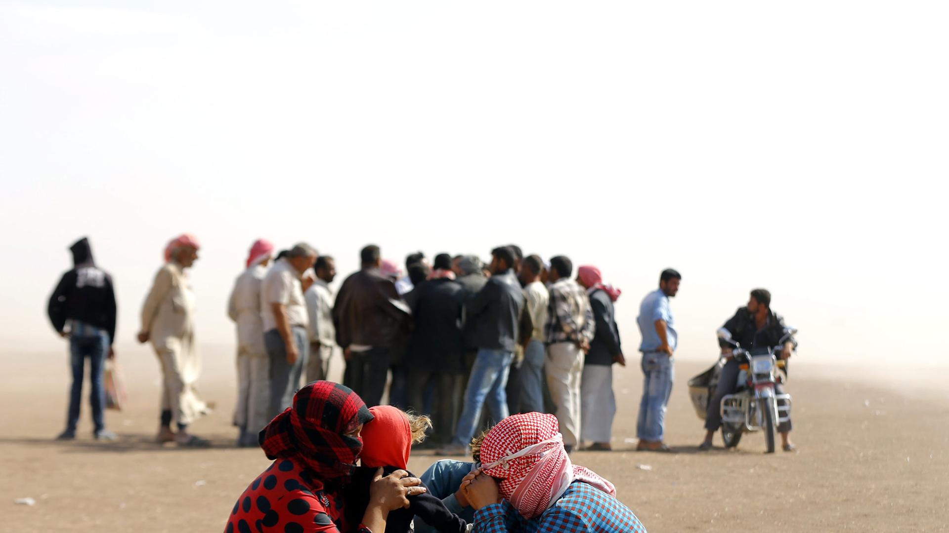 Eine Gruppe von Flüchtlingen wartet an der syrisch-türkischen Grenze nahe der Stadt Sanliurfa in der Türkei. Eine Gruppe von Flüchtlingen wartet an der syrisch-türkischen Grenze nahe der Stadt Sanliurfa in der Türkei.