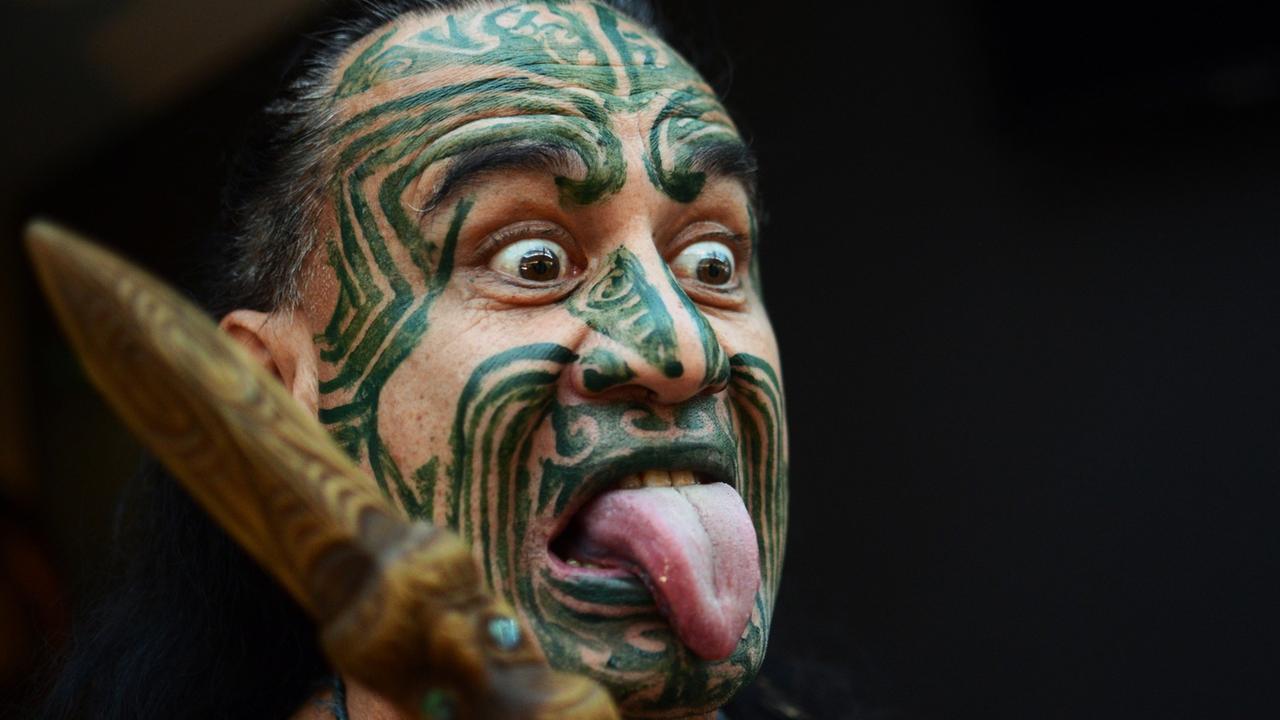 Ein Maori mit einer typischen Gesichtsbemalung und Grimasse. Ein Maori mit einer typischen Gesichtsbemalung und Grimasse.