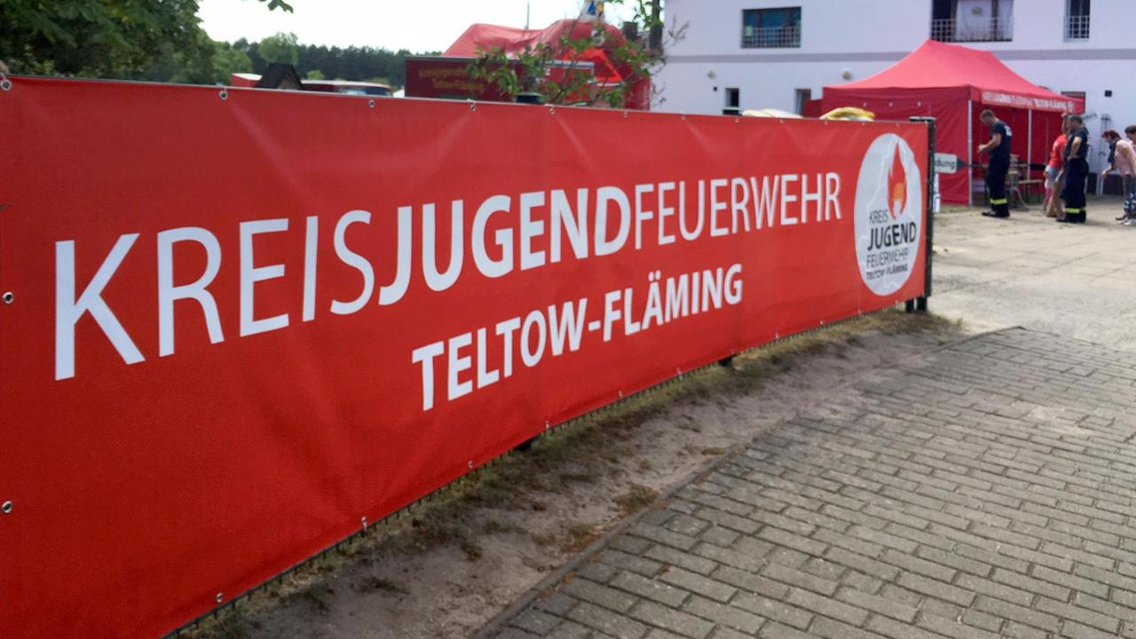 Banner der Kreisjugendfeuerwehr Teltow-Fläming, im Hintergrund das Feuerwehrgebäude.