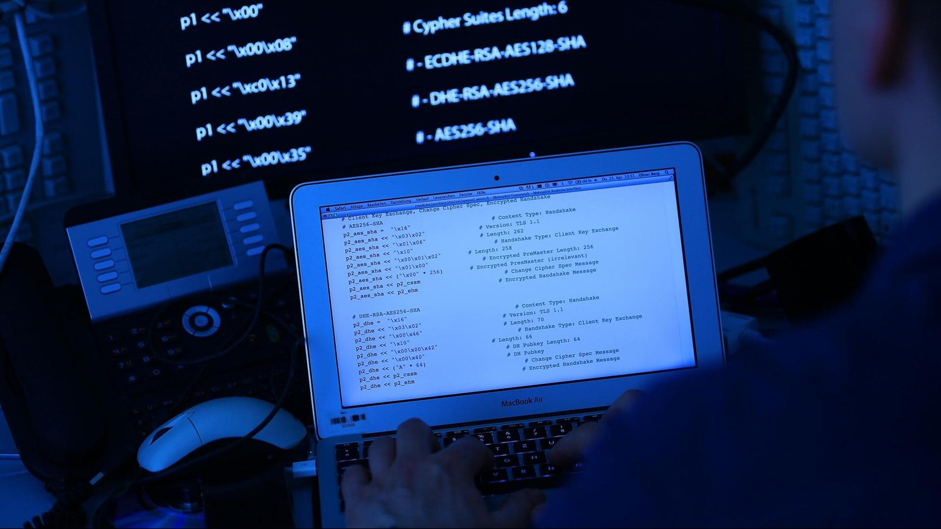 Ein Mann sitzt vor einem Rechner mit Computer Quellcode auf dem Bildschirm. Ein Mann sitzt vor einem Rechner mit Computer Quellcode auf dem Bildschirm.