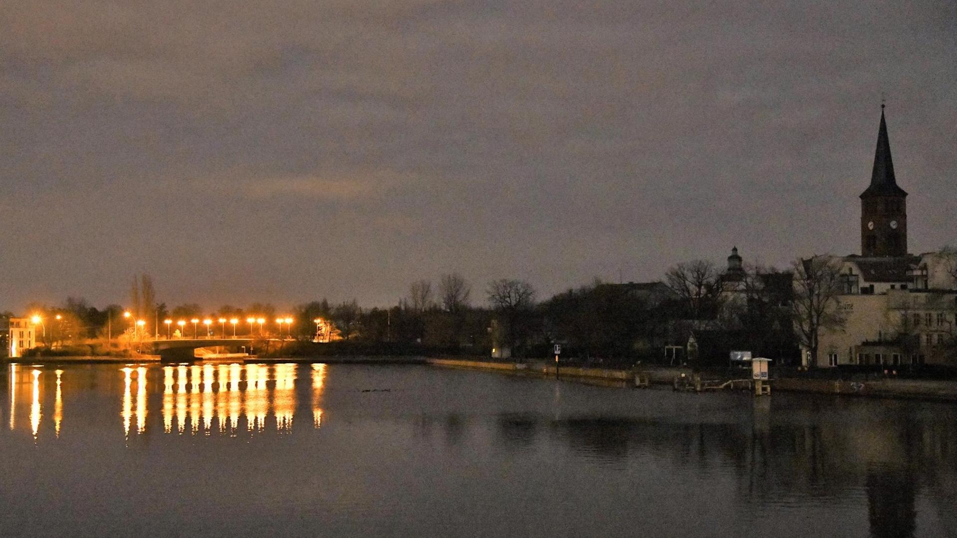 Eine Brücke über die Spree ist nachts beleuchtet, während am Ufer die Häuser und eine Kirche wegen eines Stromausfalls im Dunkeln liegen. Eine Brücke über die Spree ist nachts beleuchtet, während am Ufer die Häuser und eine Kirche wegen eines Stromausfalls im Dunkeln liegen.