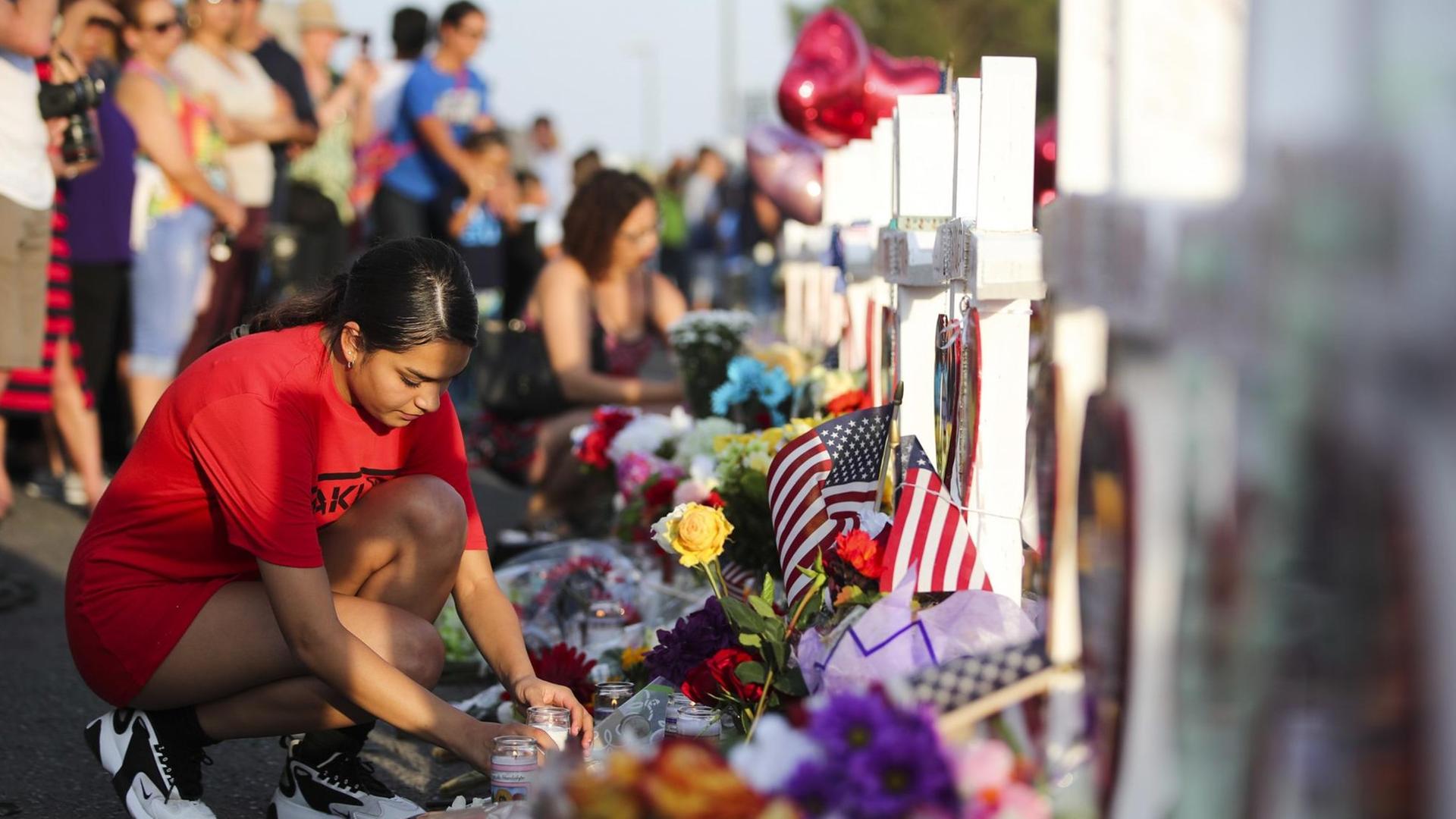 Eine Frau stellt eine Kerze auf. Das Bild zeigt Trauernde am Tatort in El Paso nach einem Massaker in einem Einkaufszentrum. Eine Frau stellt eine Kerze auf. Das Bild zeigt Trauernde am Tatort in El Paso nach einem Massaker in einem Einkaufszentrum.