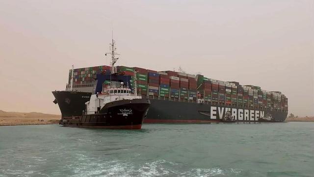 Schlepper vor dem auf Grund gelaufenen Containerschiff "Ever Given" im Suezkanal