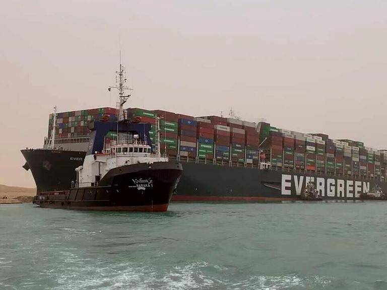 Schlepper vor dem auf Grund gelaufenen Containerschiff "Ever Given" im Suezkanal