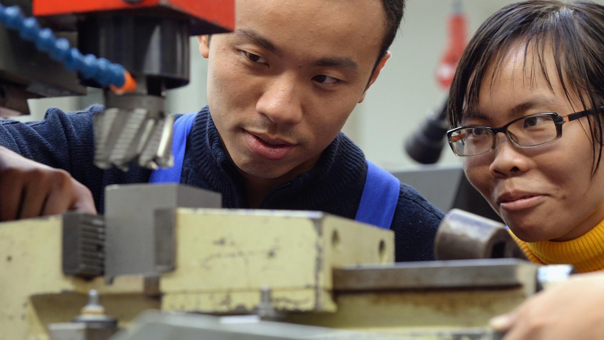 Zwei vietnamesische Arbeiter bei ihrer Ausbildung zu Mechatronikern in Chemnitz - Deutschland bleibt bei Zuwanderern beliebt. Zwei vietnamesische Arbeiter bei ihrer Ausbildung zu Mechatronikern in Chemnitz - Deutschland bleibt bei Zuwanderern beliebt.