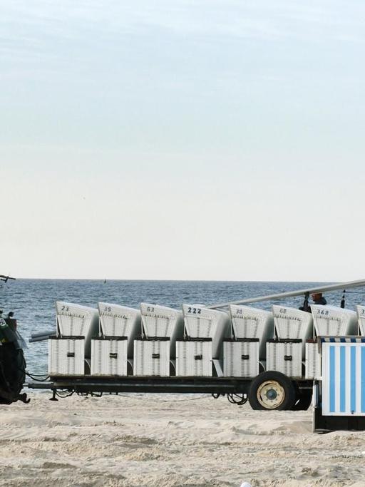 Am Strand in Warnemünde werden Strandkörbe abtransportiert.