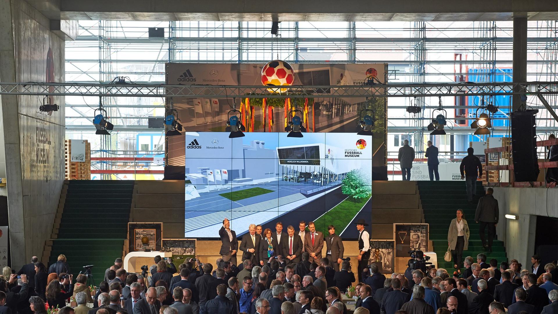 Geladene Gäste verfolgen am 04.04.2014 auf der Baustelle des Deutschen Fußballmuseums in Dortmund (Nordrhein-Westfalen) die Feierlichkeiten zum Richtfest. In dem Museumsgebäude soll eine Dauerausstellung zur deutschen Fußballgeschichte gezeigt werden. Geladene Gäste verfolgen am 04.04.2014 auf der Baustelle des Deutschen Fußballmuseums in Dortmund (Nordrhein-Westfalen) die Feierlichkeiten zum Richtfest. In dem Museumsgebäude soll eine Dauerausstellung zur deutschen Fußballgeschichte gezeigt werden.